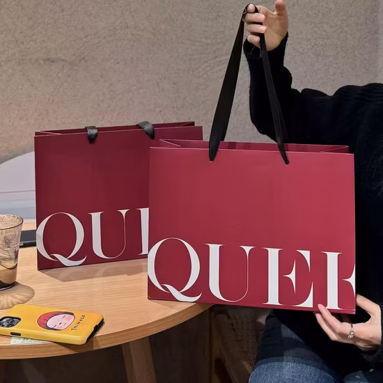 Borse per la spesa regalo di carta personalizzate di lusso stampate con logo, borse per la spesa per abbigliamento Kraft con manici, rivetti, borsa di carta per trasportare cosmetici e indumenti